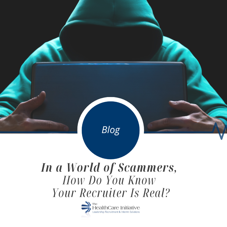 scammer with a hood over laptop