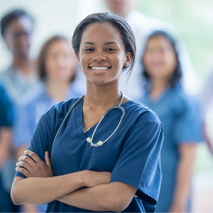 Young female nurse smiling with her team standing behind her