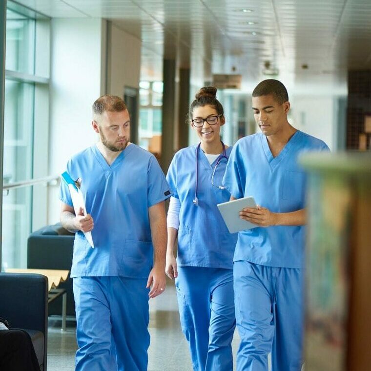 medical nurses walking down a hallway discussing with one another